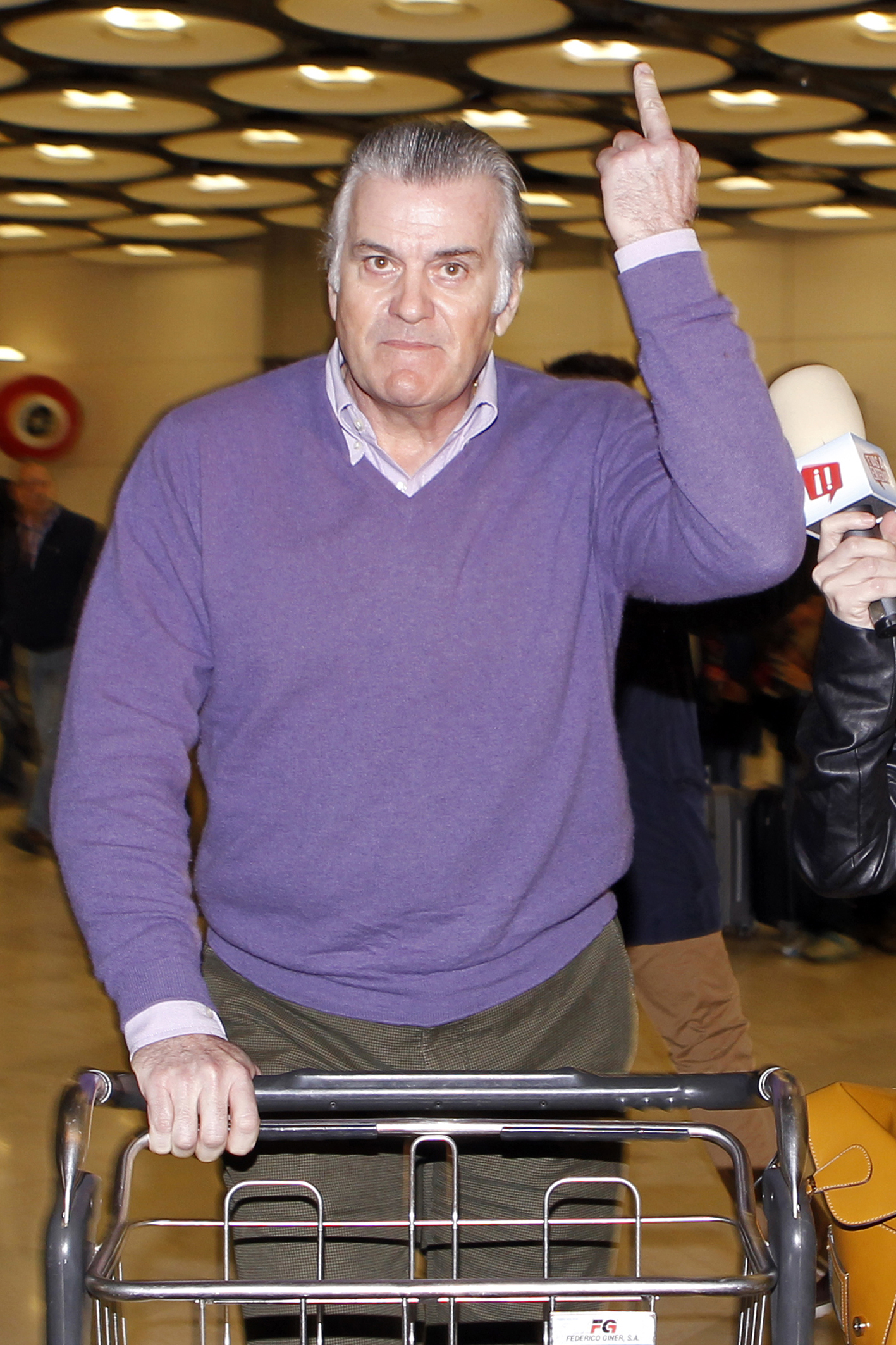 Luis Bárcenas hace un gesto despectivo con el dedo en el aeropuerto de Barajas./LALO ÁLVAREZ 